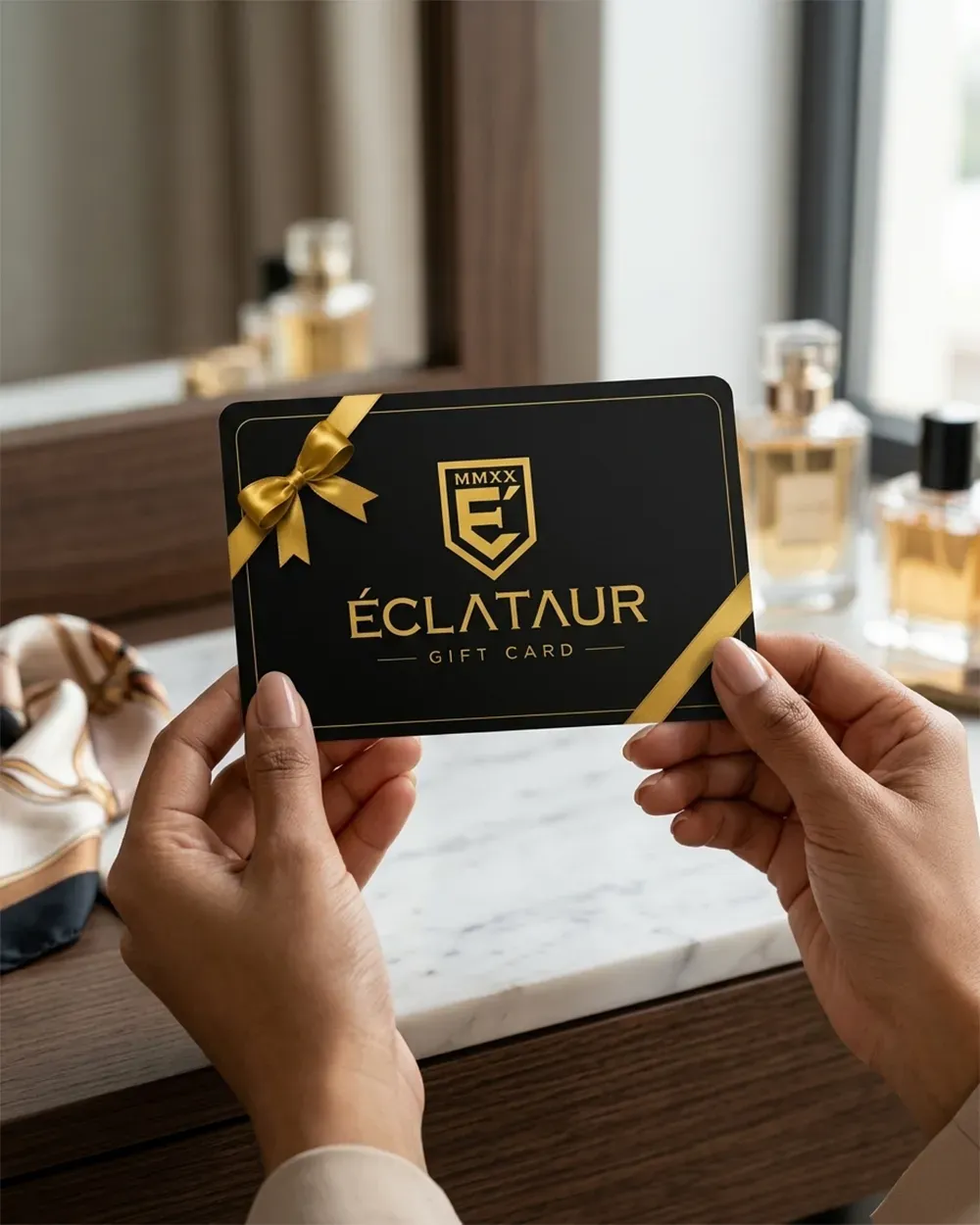 The ÉCLATAUR gift card held beside bottles from the collection, the choice it stands in for